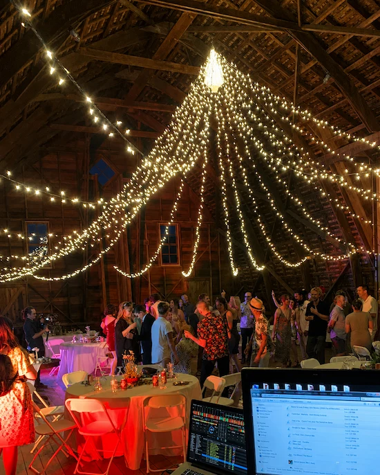 DJ booth at a string-lit reception dance floor